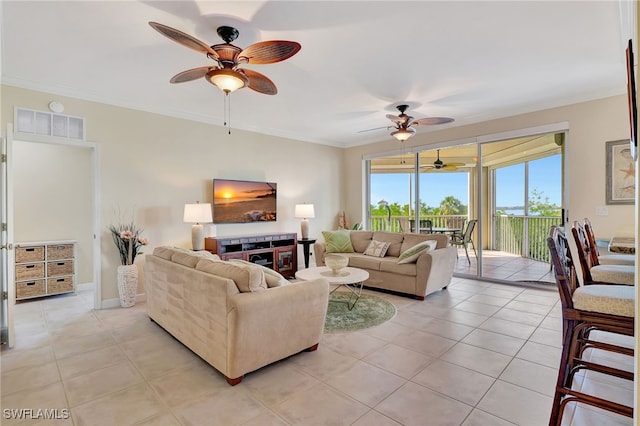 tiled living room with ornamental molding and ceiling fan