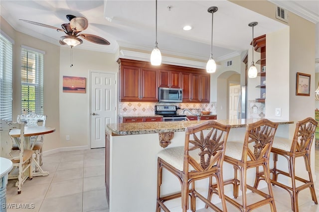 201 Vintage Bay Dr Unit B12, Marco Island, FL 34145 - kitchen with visible vents, a ceiling fan, arched walkways, backsplash, and stainless steel appliances