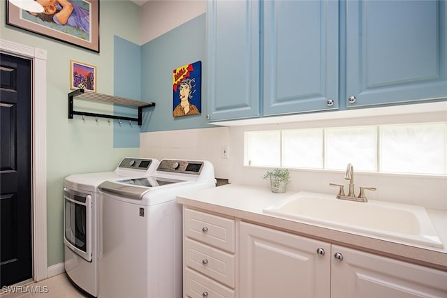 washroom with cabinets, sink, and washing machine and clothes dryer