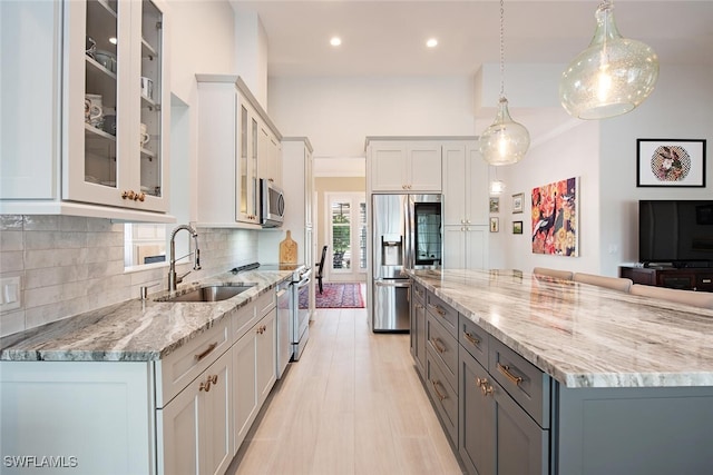 kitchen featuring pendant lighting, sink, white cabinetry, gray cabinetry, and stainless steel appliances