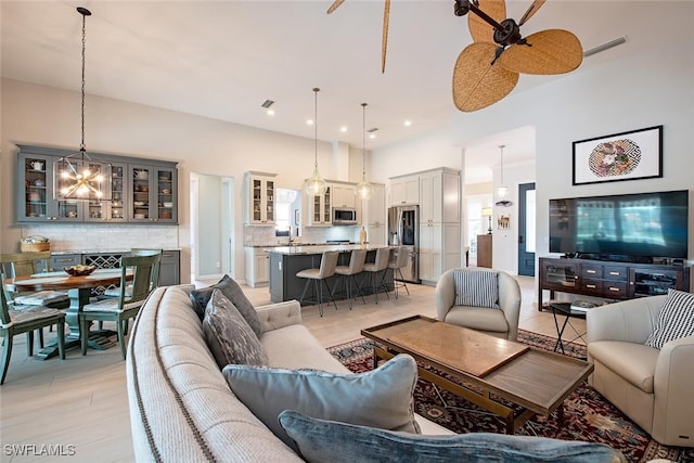 living room with ceiling fan and a towering ceiling