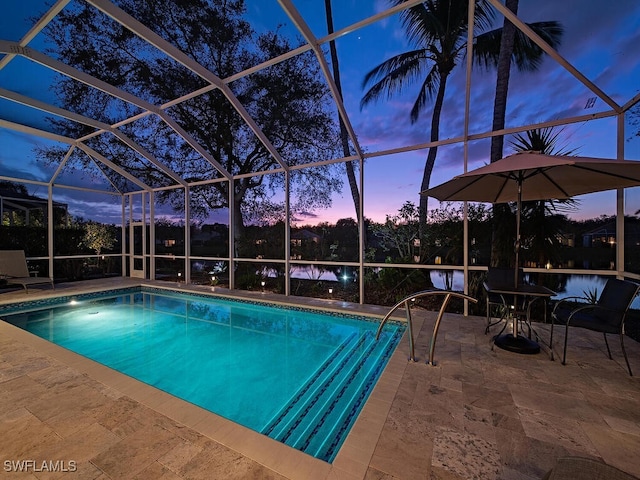 pool at dusk with a patio area and glass enclosure