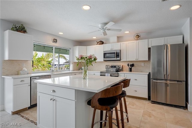 kitchen featuring a kitchen island, appliances with stainless steel finishes, and white cabinets