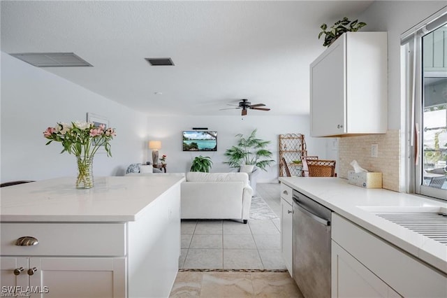 kitchen with dishwasher, ceiling fan, backsplash, a center island, and white cabinets