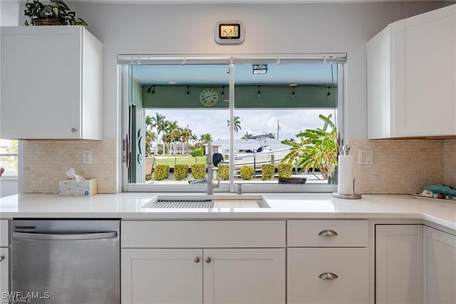 kitchen featuring white cabinetry, sink, tasteful backsplash, and stainless steel dishwasher