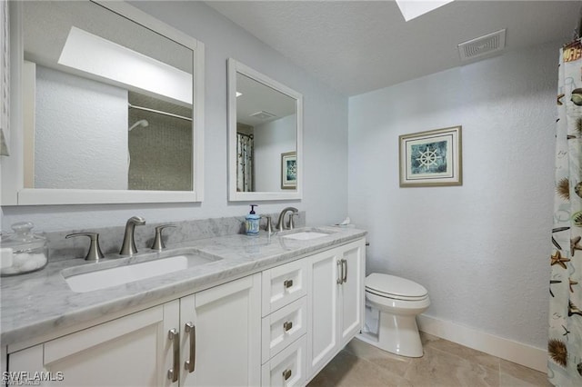 bathroom featuring tile patterned floors, vanity, toilet, and curtained shower