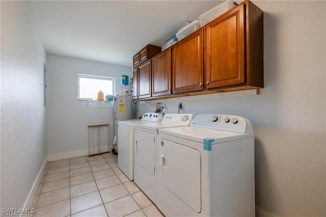 washroom featuring cabinets, electric water heater, washer and dryer, and light tile patterned floors