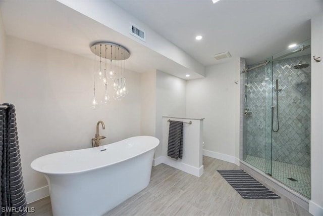 full bath with a soaking tub, a shower stall, visible vents, and baseboards