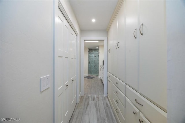 hallway featuring light wood finished floors and recessed lighting