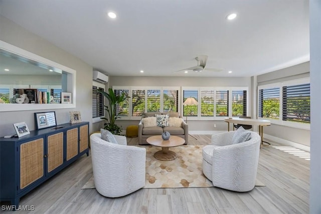 living room featuring baseboards, a wall unit AC, ceiling fan, wood finished floors, and recessed lighting