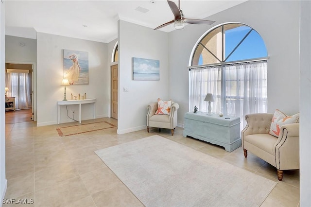 living area featuring ceiling fan, ornamental molding, a healthy amount of sunlight, and light tile patterned flooring