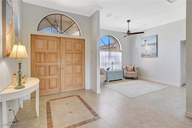 tiled foyer featuring ornamental molding and ceiling fan