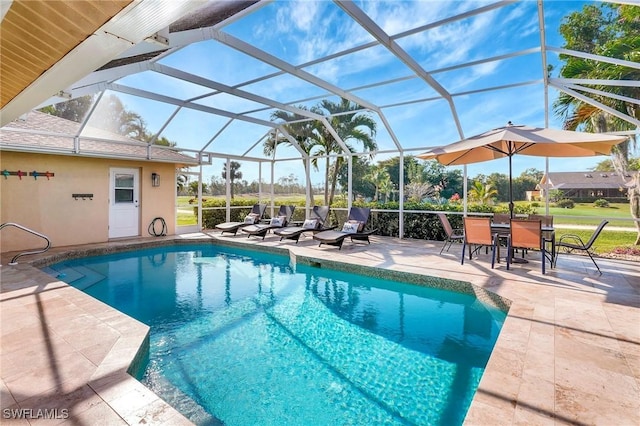 view of pool with glass enclosure and a patio area