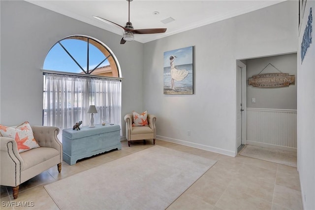 living area with crown molding, light tile patterned floors, and ceiling fan