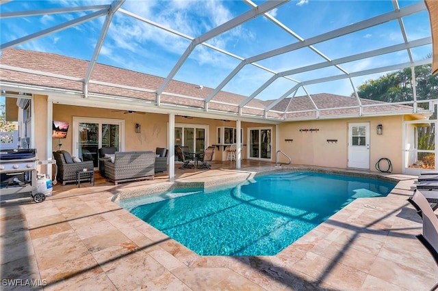 view of swimming pool with an outdoor living space, a lanai, a patio, and ceiling fan