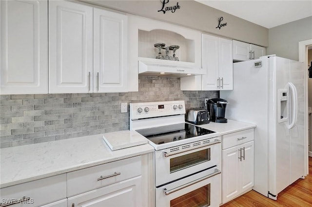 kitchen with custom exhaust hood, light hardwood / wood-style flooring, white cabinets, white appliances, and backsplash