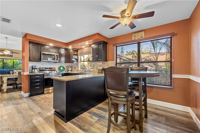 kitchen with appliances with stainless steel finishes, sink, dark brown cabinetry, and decorative backsplash