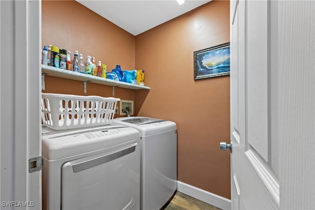 clothes washing area featuring washer and dryer and light hardwood / wood-style flooring