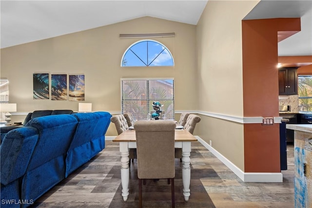 dining space featuring dark hardwood / wood-style flooring, high vaulted ceiling, and a wealth of natural light