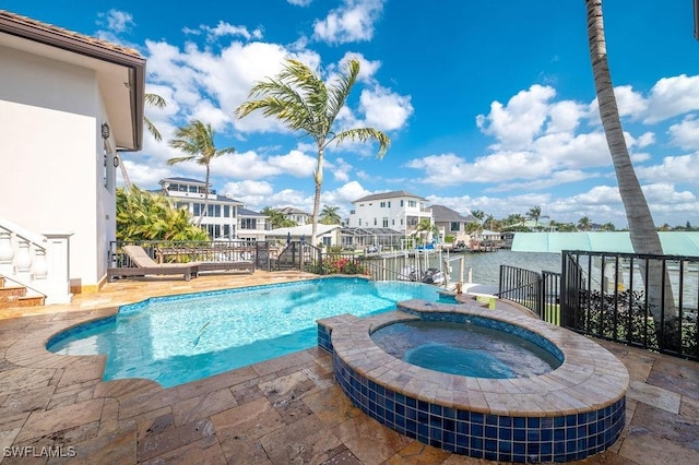 view of pool with an in ground hot tub and a water view