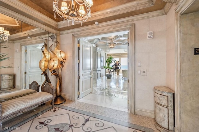 hallway with ornamental molding, tile walls, and a notable chandelier