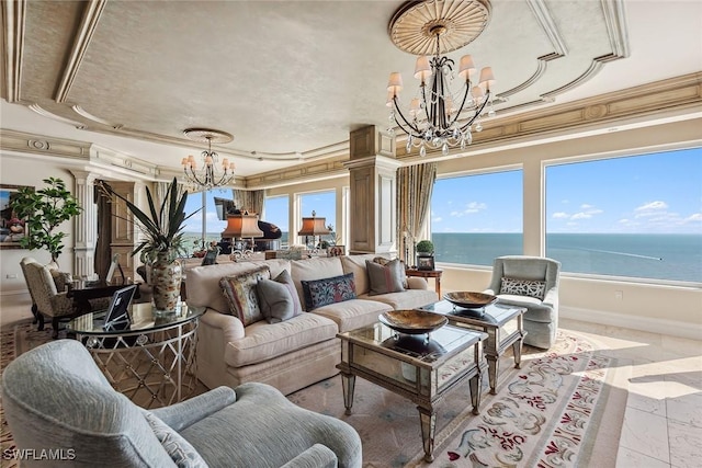 living room featuring ornamental molding, decorative columns, a chandelier, and a water view