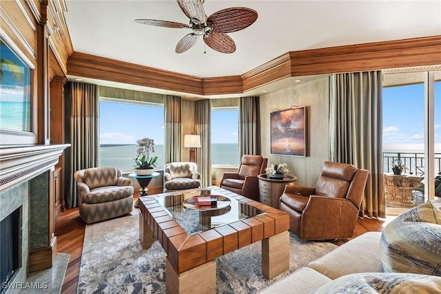 living room with a water view, light wood-type flooring, a wealth of natural light, and a fireplace