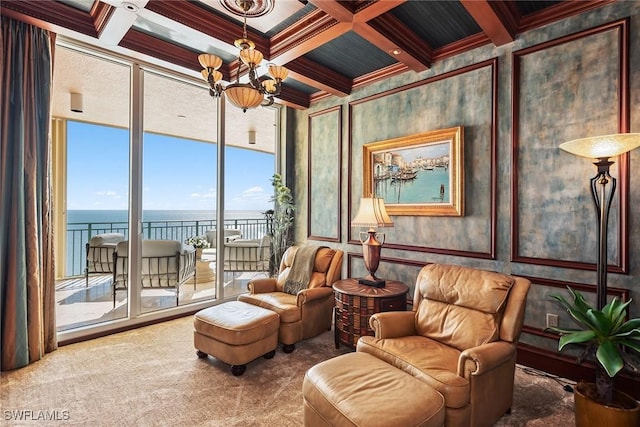 living area with a water view, beam ceiling, a chandelier, and carpet