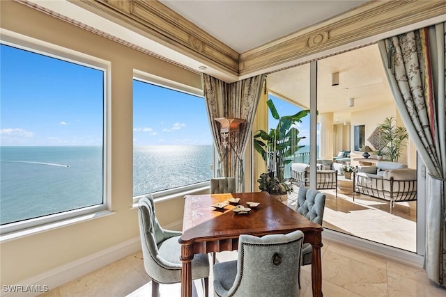 sunroom / solarium featuring a water view