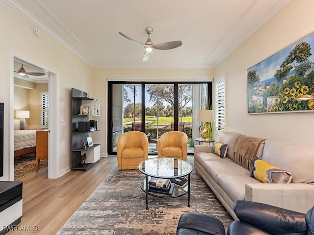 living area featuring ornamental molding, ceiling fan, light wood finished floors, and baseboards