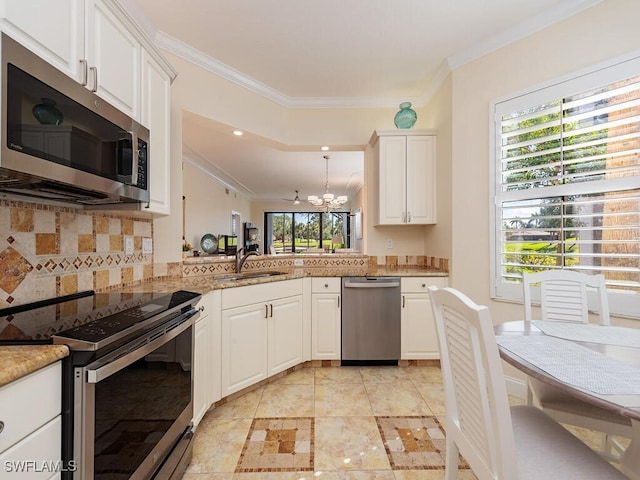 kitchen with tasteful backsplash, appliances with stainless steel finishes, ornamental molding, a sink, and a notable chandelier