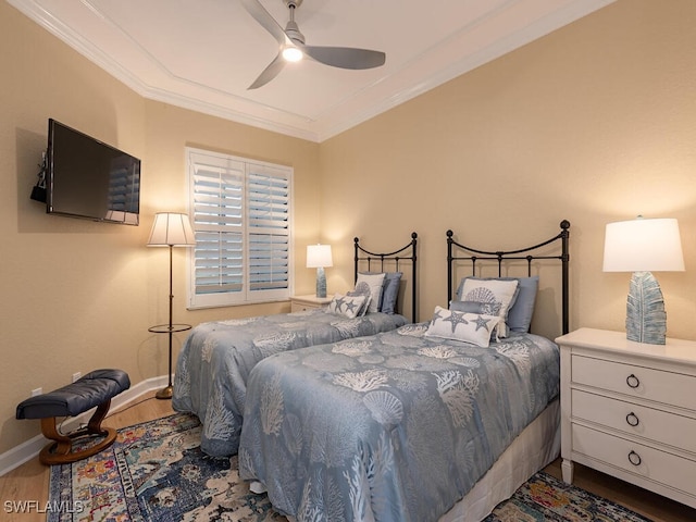 bedroom featuring ornamental molding, wood finished floors, a ceiling fan, and baseboards