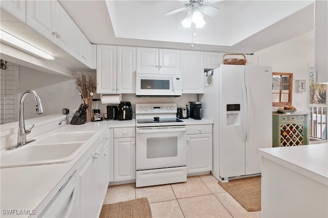 kitchen with white cabinetry, sink, white appliances, and a tray ceiling