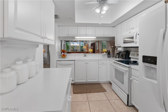 kitchen with light tile patterned flooring, sink, white cabinets, ceiling fan, and white appliances