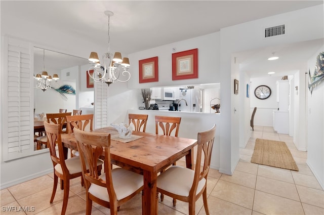 tiled dining room with a chandelier and sink