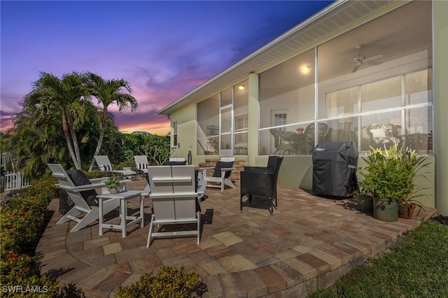 patio terrace at dusk with ceiling fan, grilling area, and outdoor lounge area