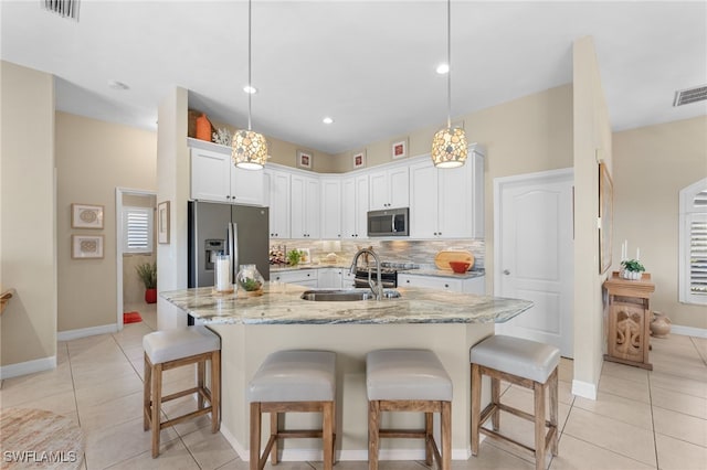 kitchen featuring appliances with stainless steel finishes, pendant lighting, tasteful backsplash, sink, and white cabinets