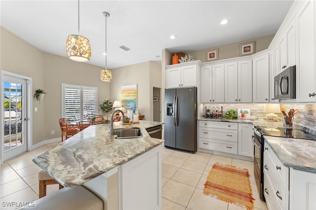 kitchen featuring light tile patterned floors, tasteful backsplash, stainless steel appliances, white cabinetry, and a sink