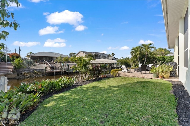 view of yard with a water view and a patio