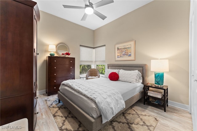 bedroom with light wood-type flooring, baseboards, and a ceiling fan