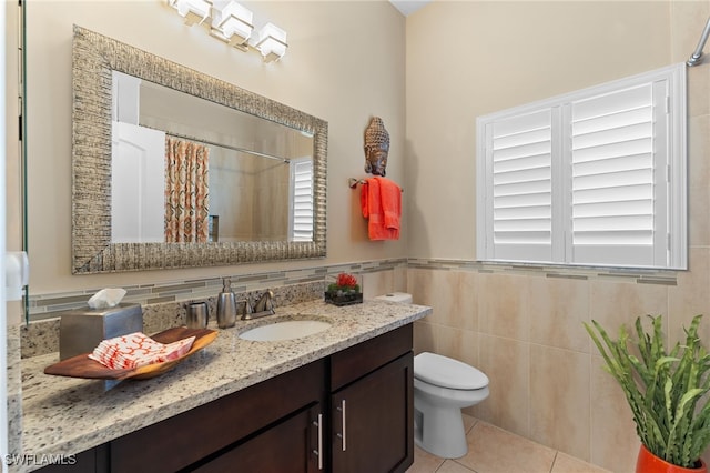 bathroom with tile patterned flooring, tile walls, vanity, a shower with curtain, and toilet