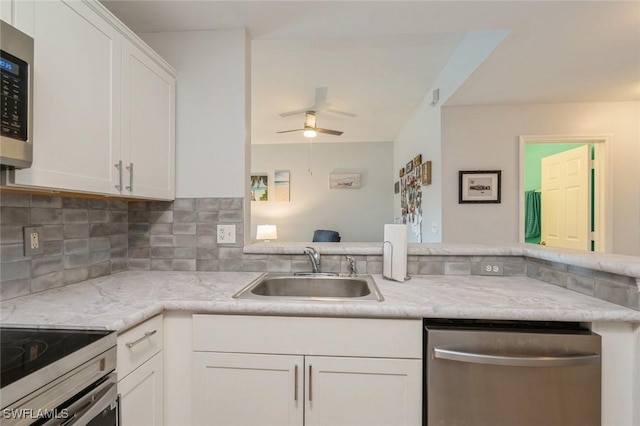 kitchen with sink, decorative backsplash, stainless steel appliances, and white cabinets