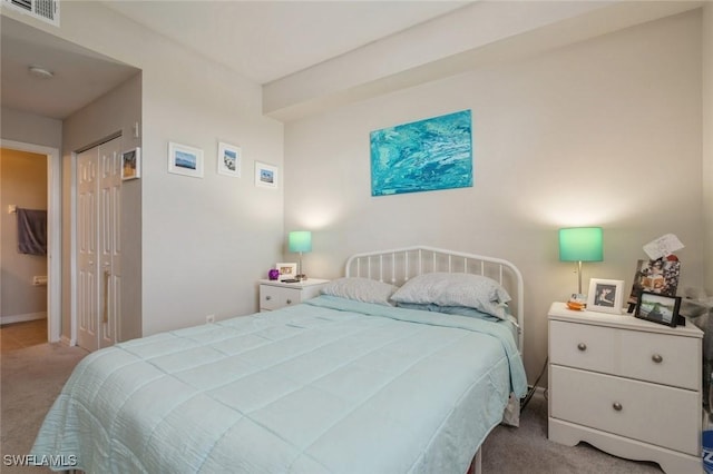 bedroom featuring light colored carpet and a closet