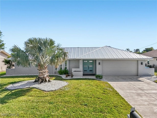 view of front facade featuring driveway, metal roof, french doors, and stucco siding