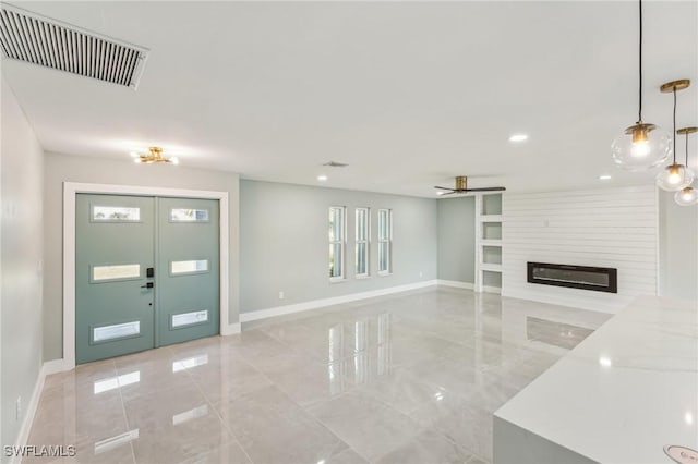 interior space with a fireplace, french doors, and ceiling fan