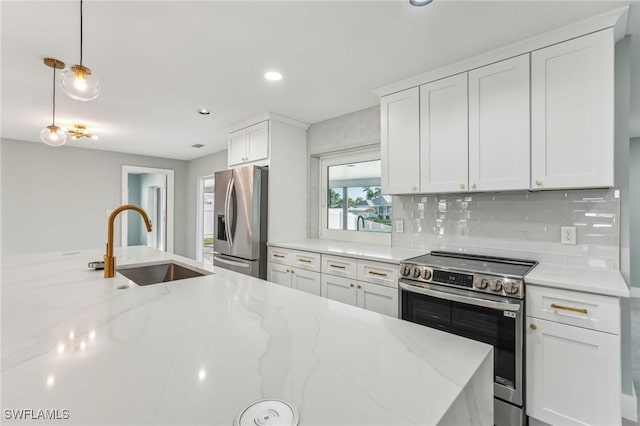 kitchen with a sink, white cabinetry, appliances with stainless steel finishes, tasteful backsplash, and decorative light fixtures