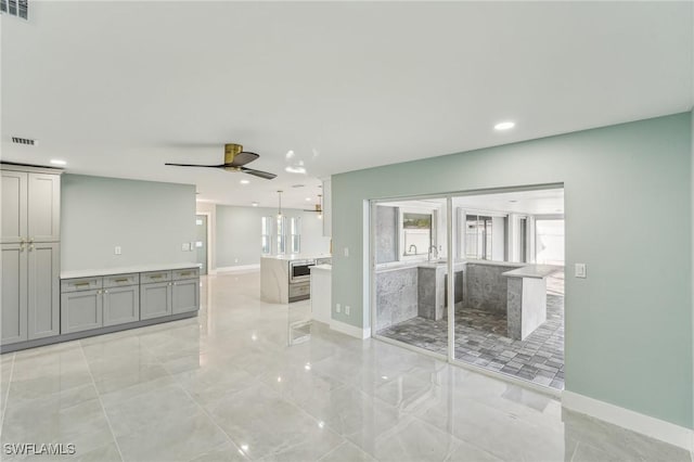 unfurnished living room with baseboards, visible vents, a ceiling fan, and recessed lighting