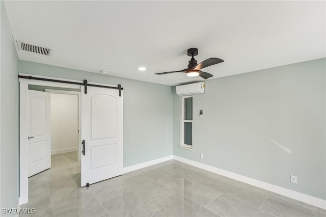 unfurnished bedroom featuring a barn door, a wall unit AC, a ceiling fan, visible vents, and baseboards