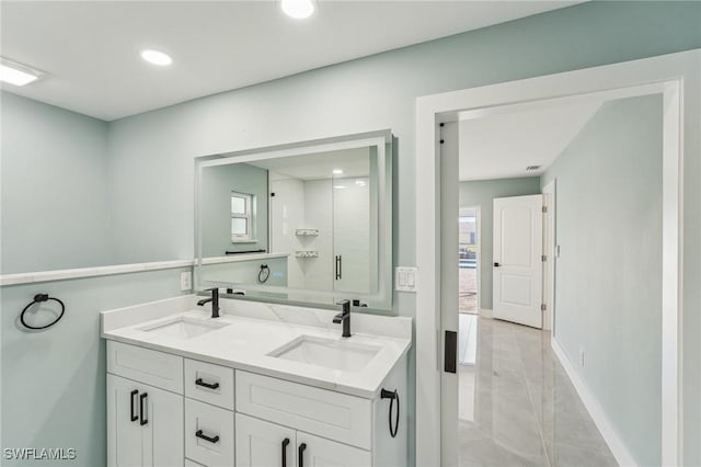 full bath with double vanity, baseboards, a sink, and recessed lighting