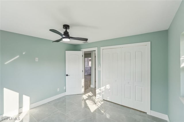 unfurnished bedroom with a closet, a ceiling fan, and baseboards